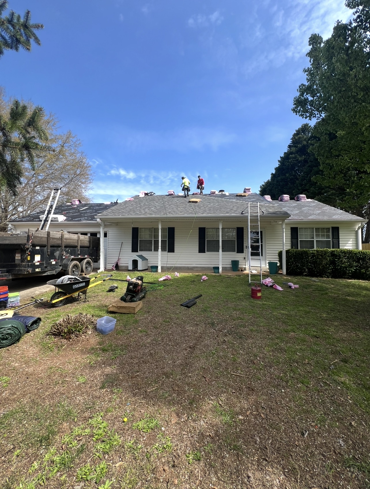 RID-ICK roof replacement in progress with crew, trailer and roofing materials on site