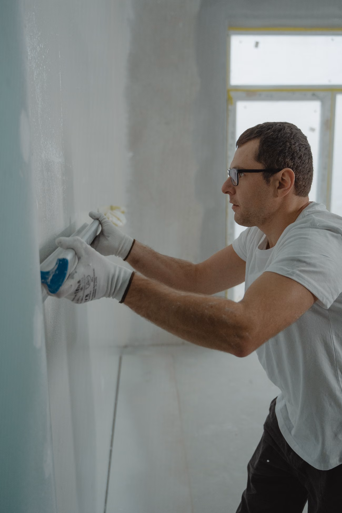 Worker repairing an interior wall during a residential renovation