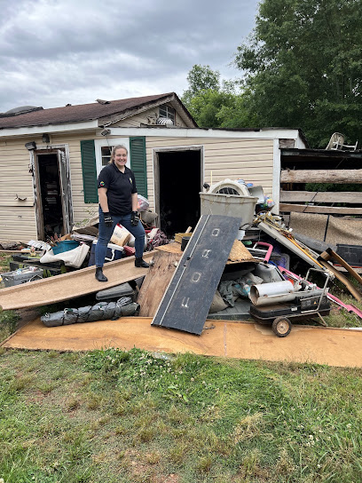 RID-ICK Rescue team member beside a real property cleanout pile